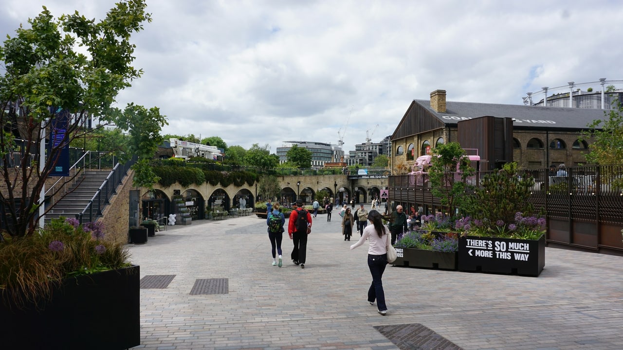 People walking through Coal Drops Yard at King's Cross on a bright day