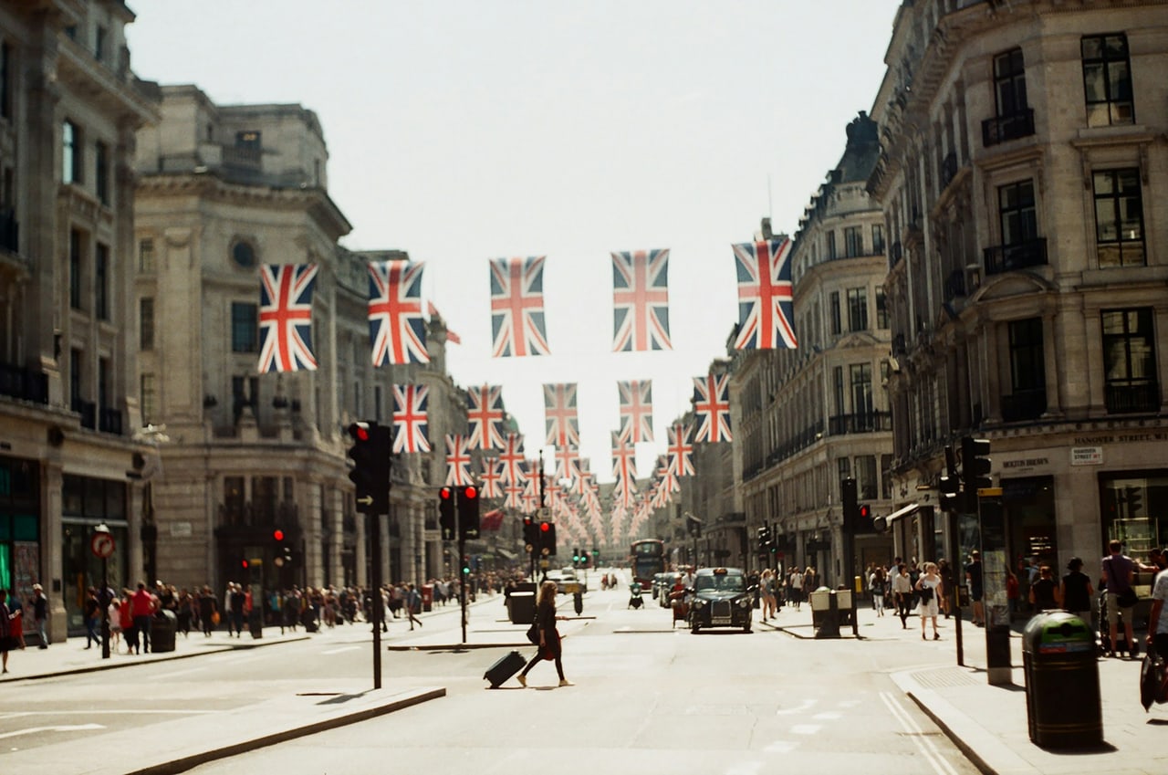 Union flags strung across Regent Street above shoppers and a black cab